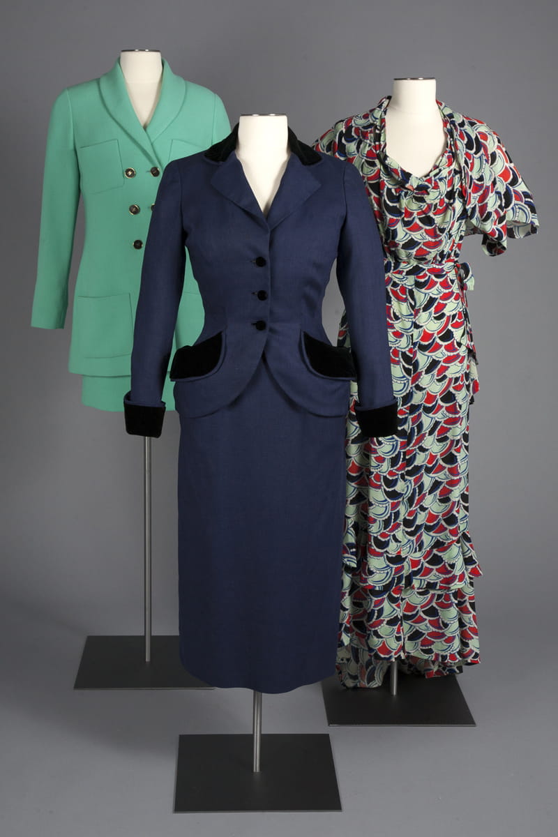 Skirt suits by Chanel and Dior, and a printed silk crepe evening dress from 1929.