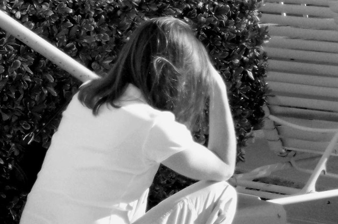 A woman sitting with her head in her hands.
