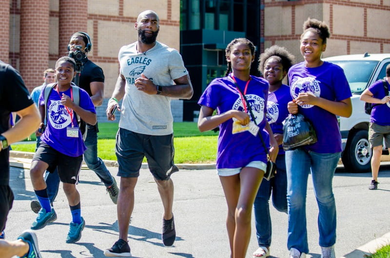Eagles safety Malcolm Jenkins runs around the team's training facility with a group of Young Dragons.