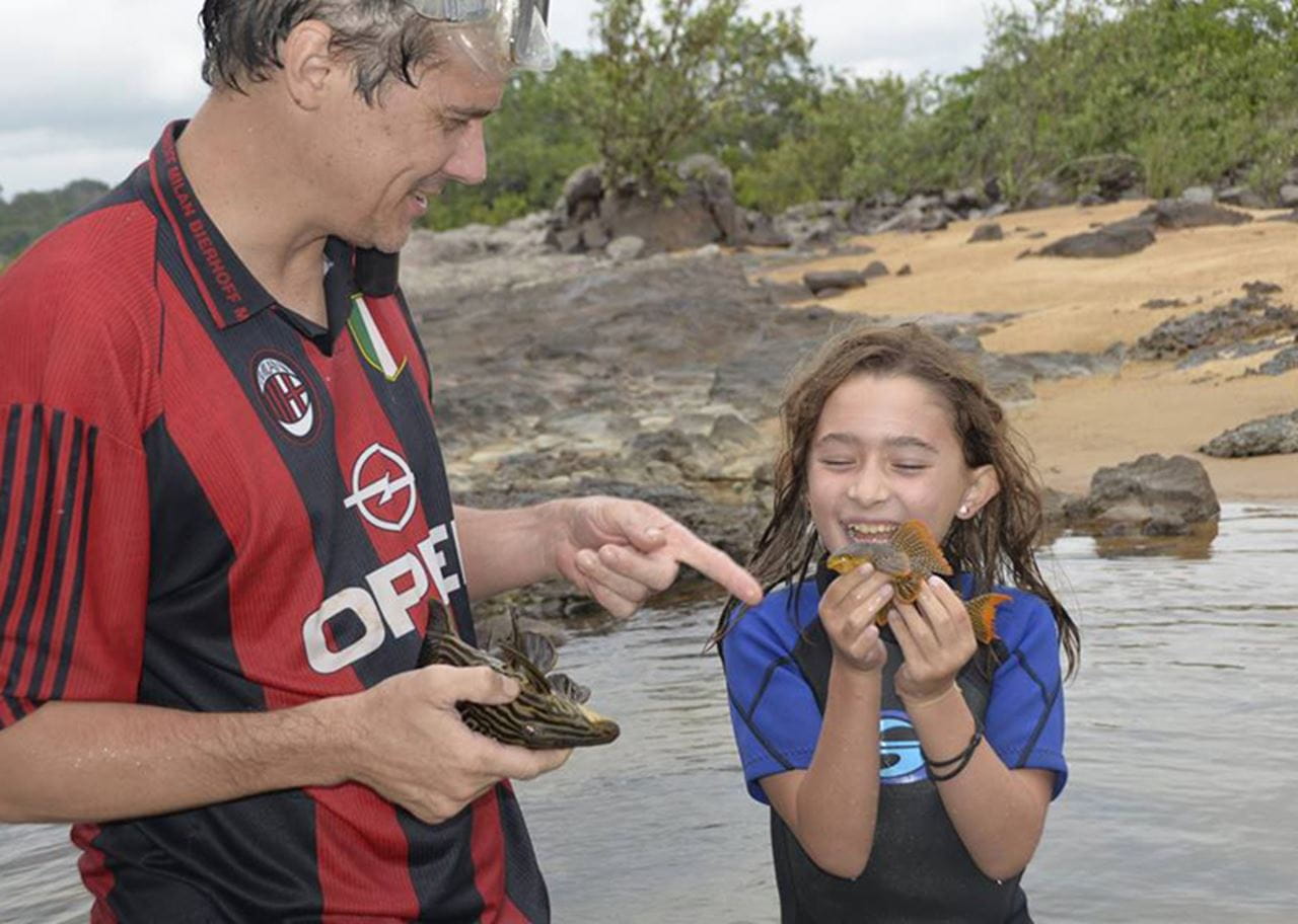 Sabah pointing at a fish Sofia is holding.