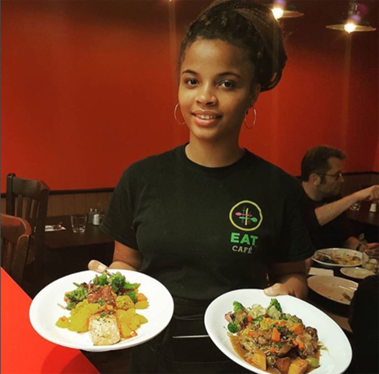 A server holding dishes of food.