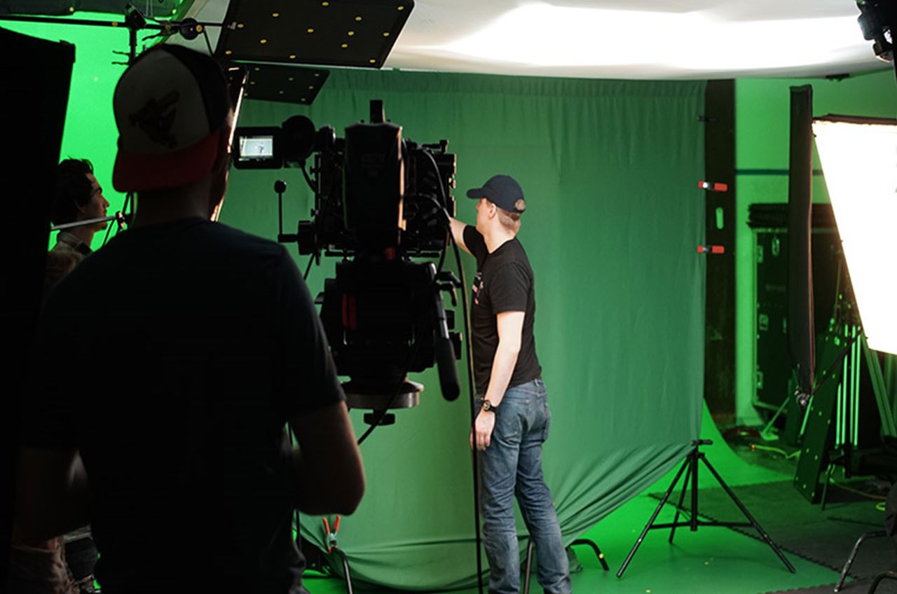Eric Hiller testing the feel of the green wall that the main actor interacts with. The wall will be replaced with a computer-generated spiral wall of paintings that can be thrown by the actor. Hiller is making sure the wall is lit evenly for easy green screen keying but also sturdy enough for the actor to really push and sell the weight of the wall as a real object.