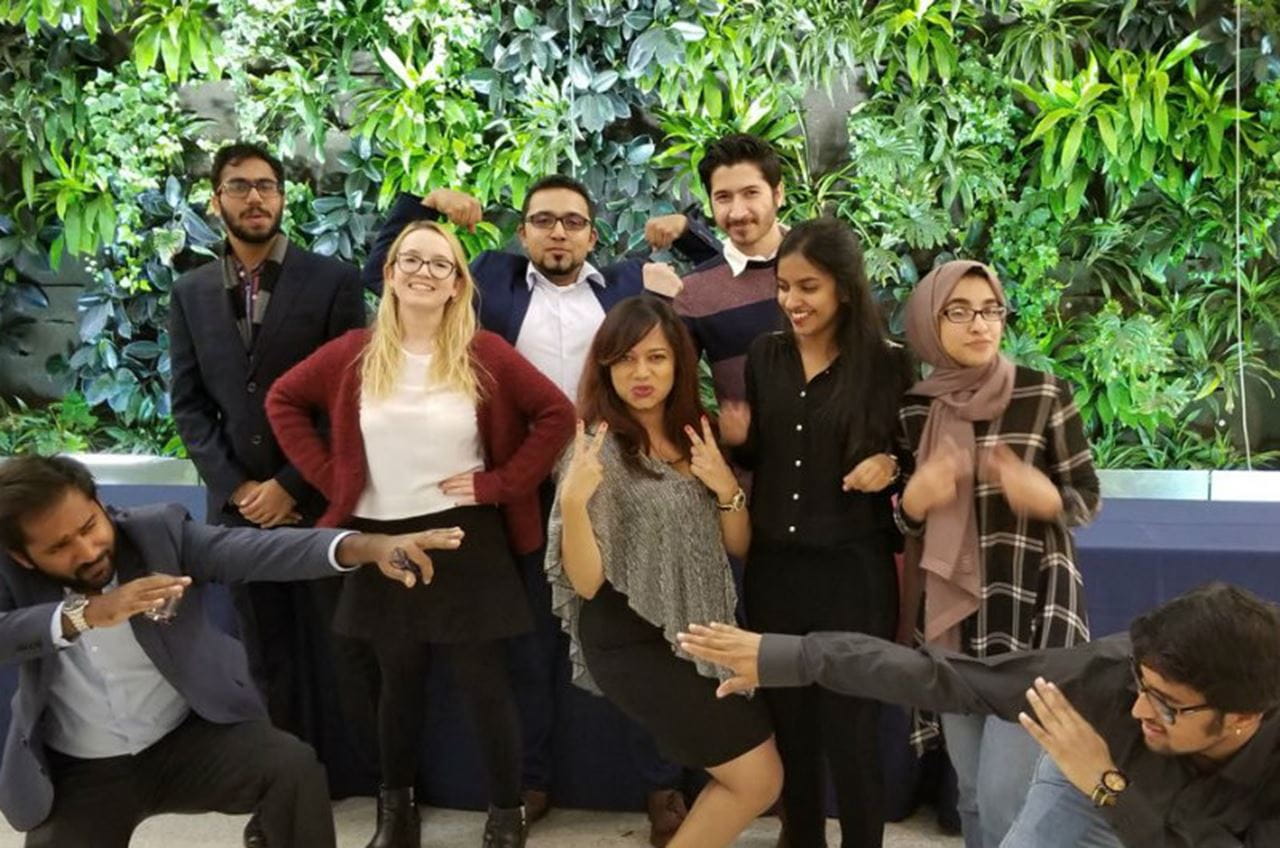Members of the International Graduate Student Association in front of the biowall prior to their Thanksgiving dinner.