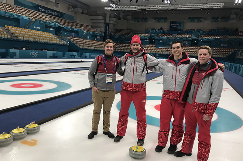 Ryan Roe, left, with coworkers in the curling arena at the 2018 Winter Olympics. 