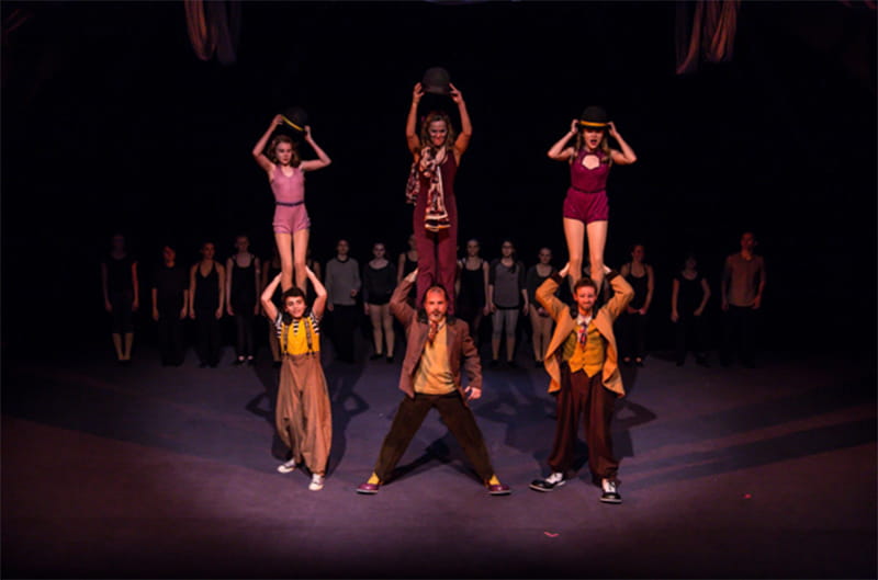 The Actors Gymnasium performs “Marie and Phil: A Circus Love Letter” (2015). Nico Añón is the bottom left performer. Photo courtesy of The Actors Gymnasium.