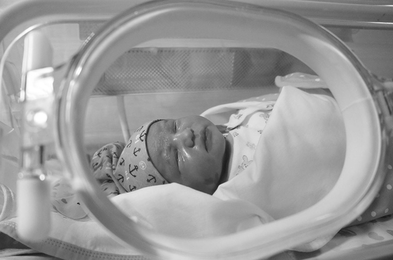 A baby laying in an incubator