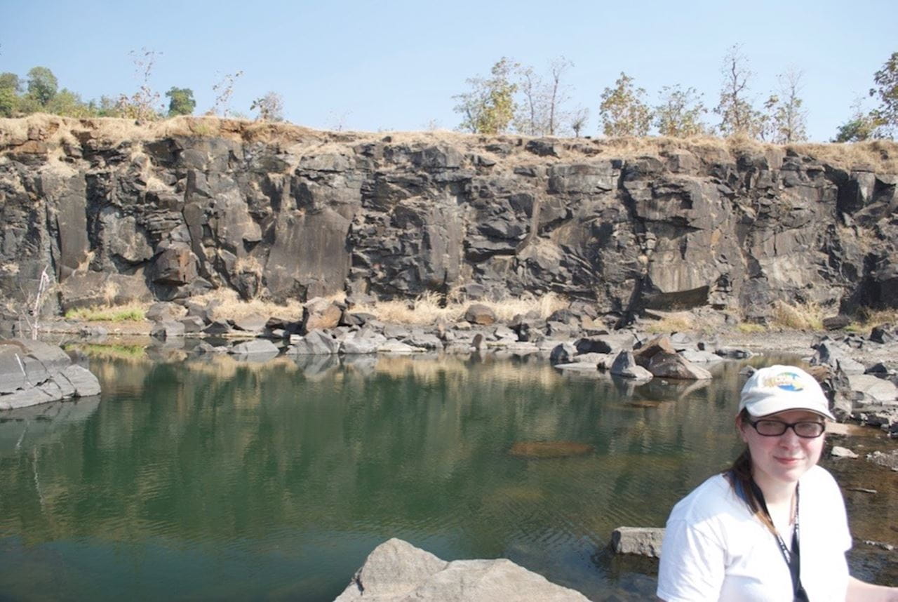 Lead author Courtney Sprain standing in front of an inflated sheet lobe in the Jawhar Formation, in a quarry north of Mumbai. Image credit, Loÿc Vanderkluysen.