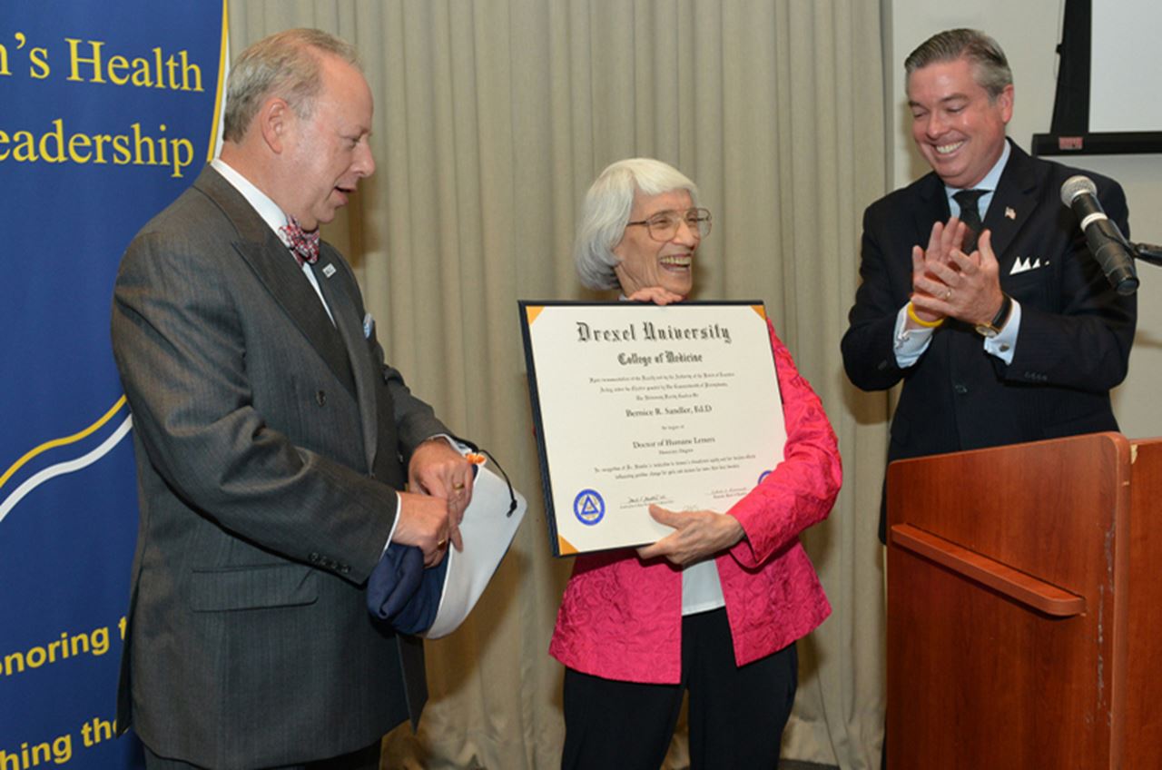 Bernice Sandler, EdD, received an honorary degree from Drexel University in 2013. Drexel President John Fry (right) applauds Sandler, as College of Medicine Dean Daniel V. Schidlow, MD, prepares to present her with the doctoral hood.