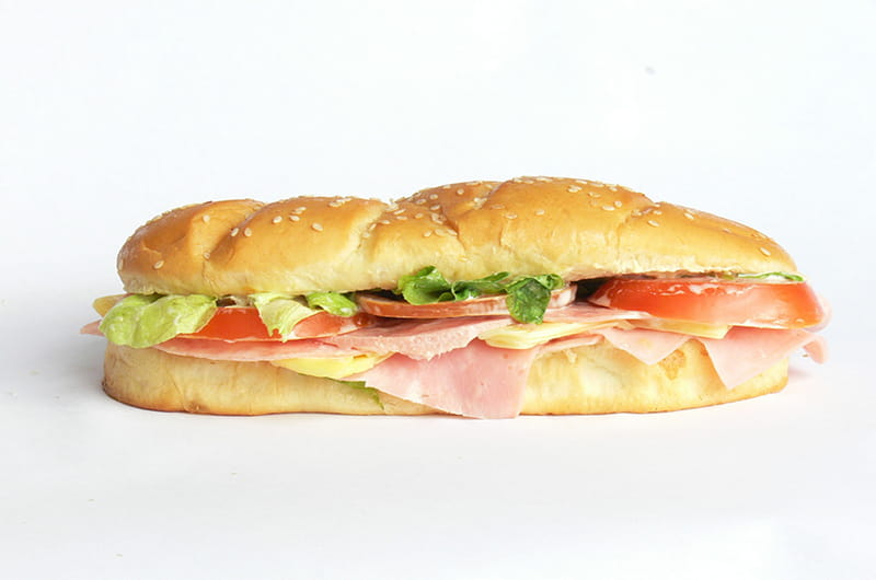 Hoagie with meat, cheese, lettuce and tomato. 