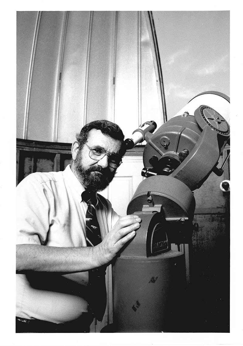A photo from 1987  featuring Leonard R. Cohen, PhD, in front of the observatory with a telescope. Photo courtesy Drexel University Archives.