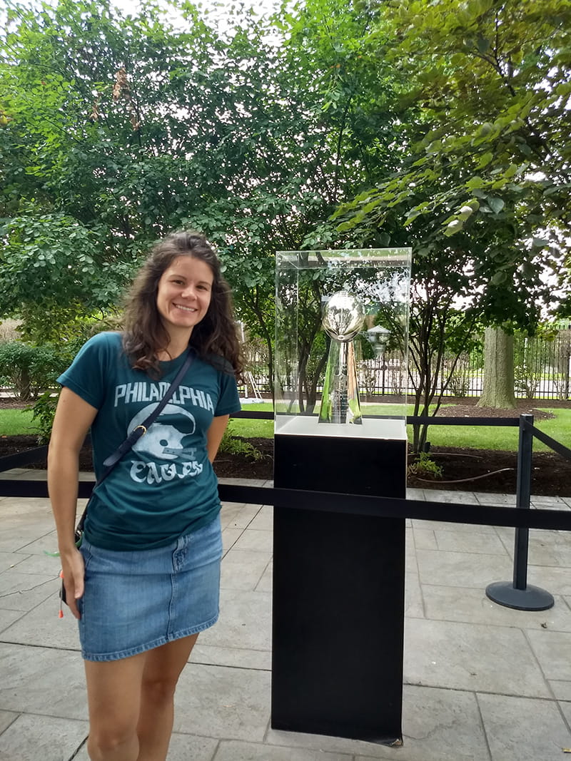 Jessica Rast, MPH ’14, research associate in the A.J. Drexel Autism Institute, stands next to the Vince Lombardi trophy. She was a virtual participant in last year's Eagles Autism Challenge and will run in this year's event.