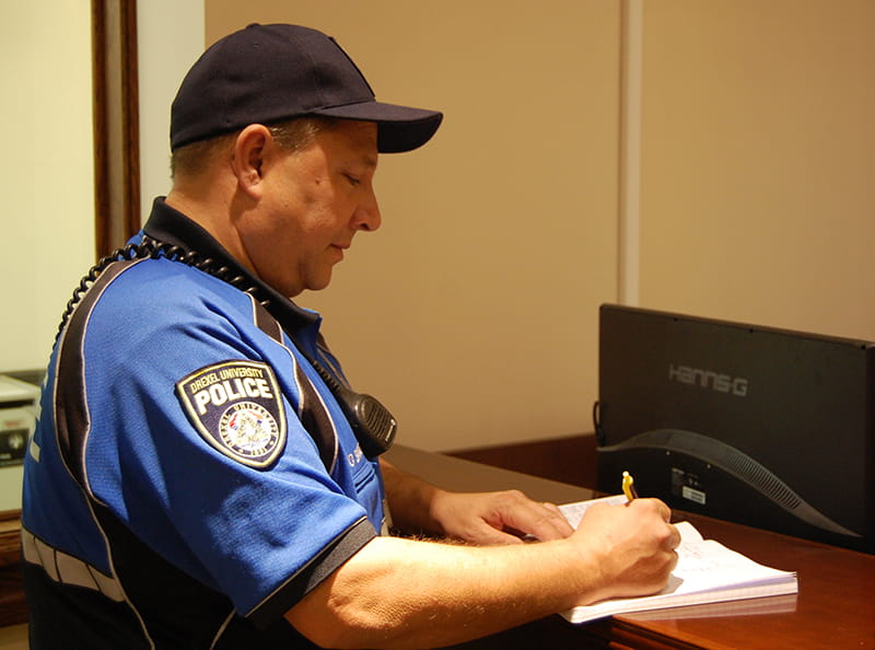 Officer Barone signs a logbook marking his patrol route throughout campus.