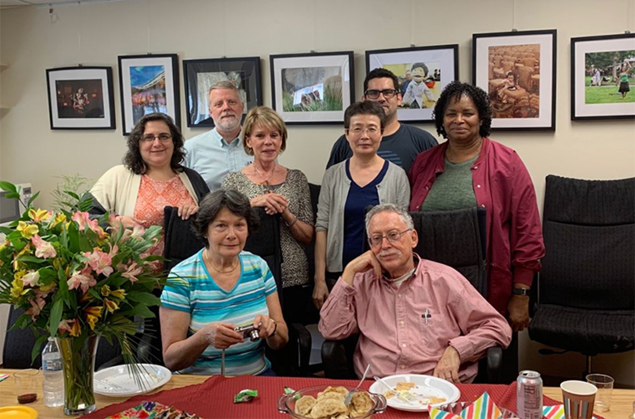 A pre-pandemic photo of the Fischer Lab and office celebrating. First row left to right: Department of Neurobiology & Anatomy Lab Manager Maryla Obrocka and Professor and Chair Itzhak Fischer, PhD. Second row: Financial Analyst Anna Maria Falco, Spinal Cord Research Group Manager Theresa Connors, Research Assistant Professor Ying Jin, PhD, and Project and Teaching Coordinator Joy Hudson. Back row: Research Assistant Professor B. Timothy Himes, PhD, and Senior Technician Julien Bouyer. In background, a photo exhibition by faculty. Photo courtesy Itzhak Fischer, PhD.