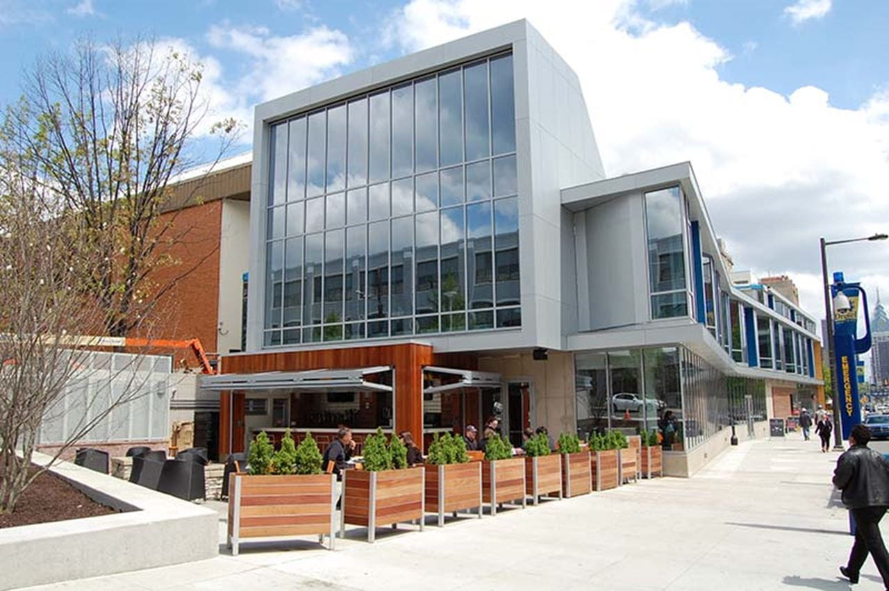 A photo from April 2010 showing the patio area of Landmark Americana Tap & Grille, with the climbing wall located behind the windows on the second floor. 
