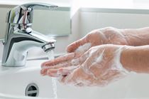 hands being washed with soap and water