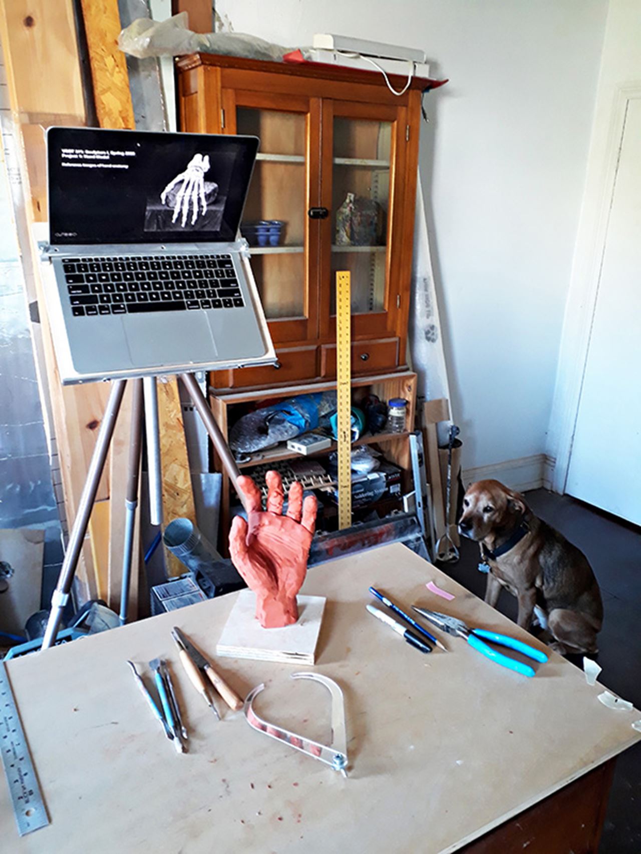 Professor Lewis Colburn sets up a demonstration station at home to show his Sculpture I students how to make their hand model in oil clay.