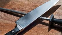 knife and honing stick on wood cutting board