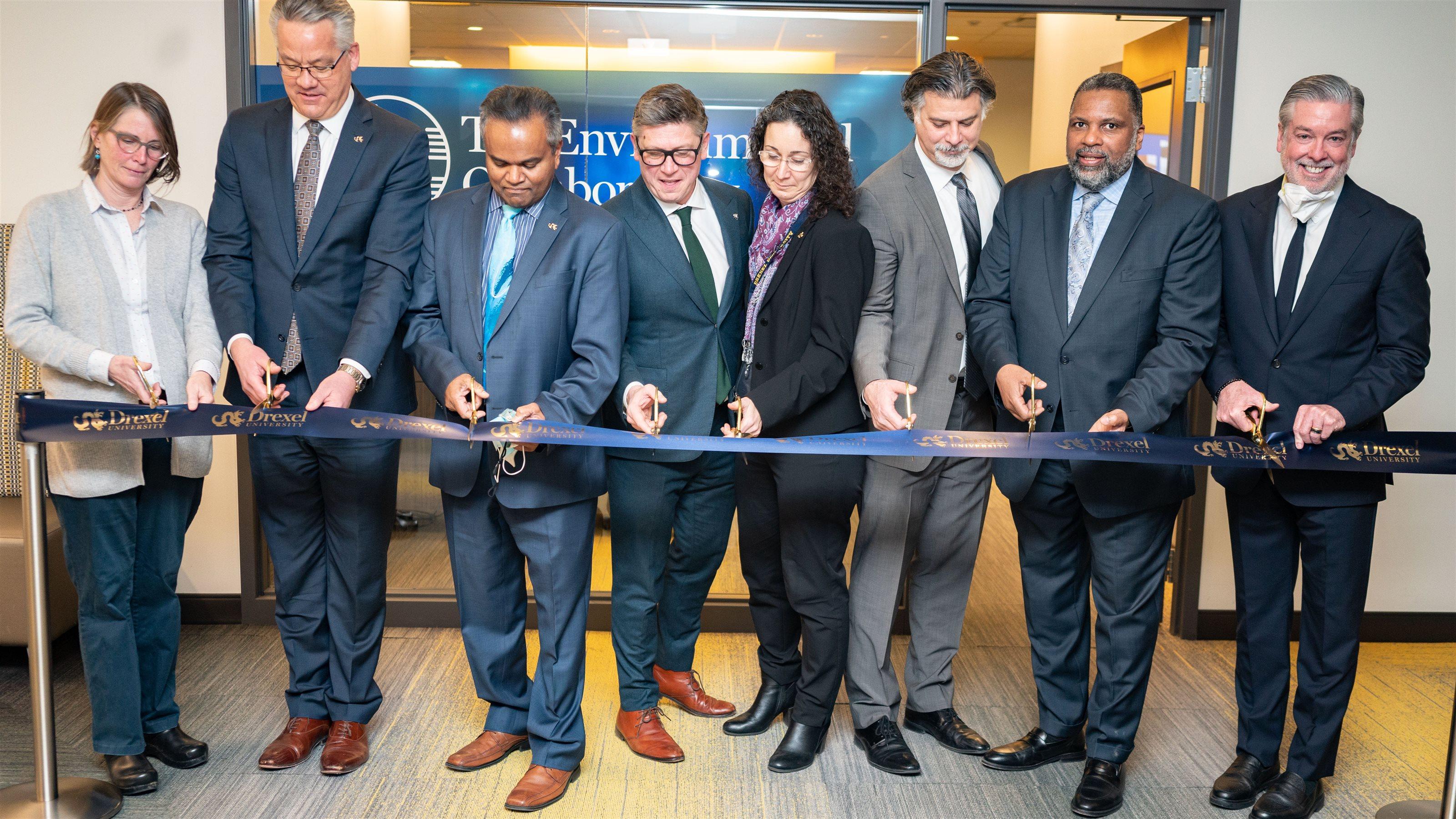 A group of people cutting a ribbon as part of the opening of The Environmental Collaboratory.
