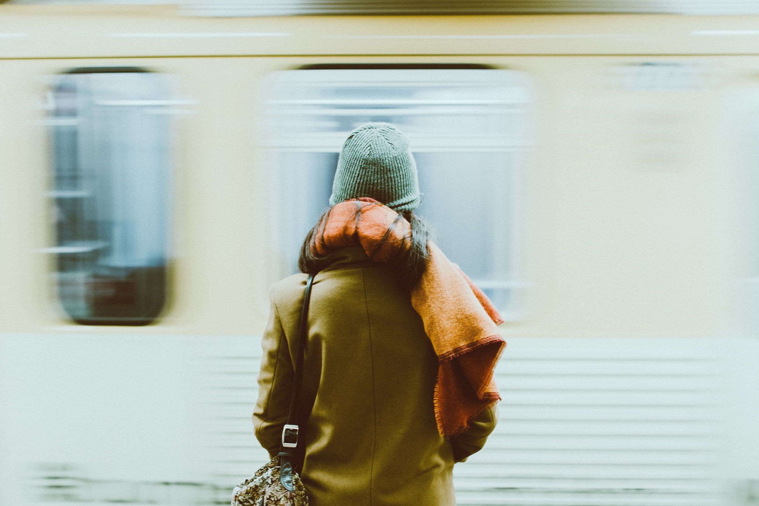 A person stands in front of a subway. 