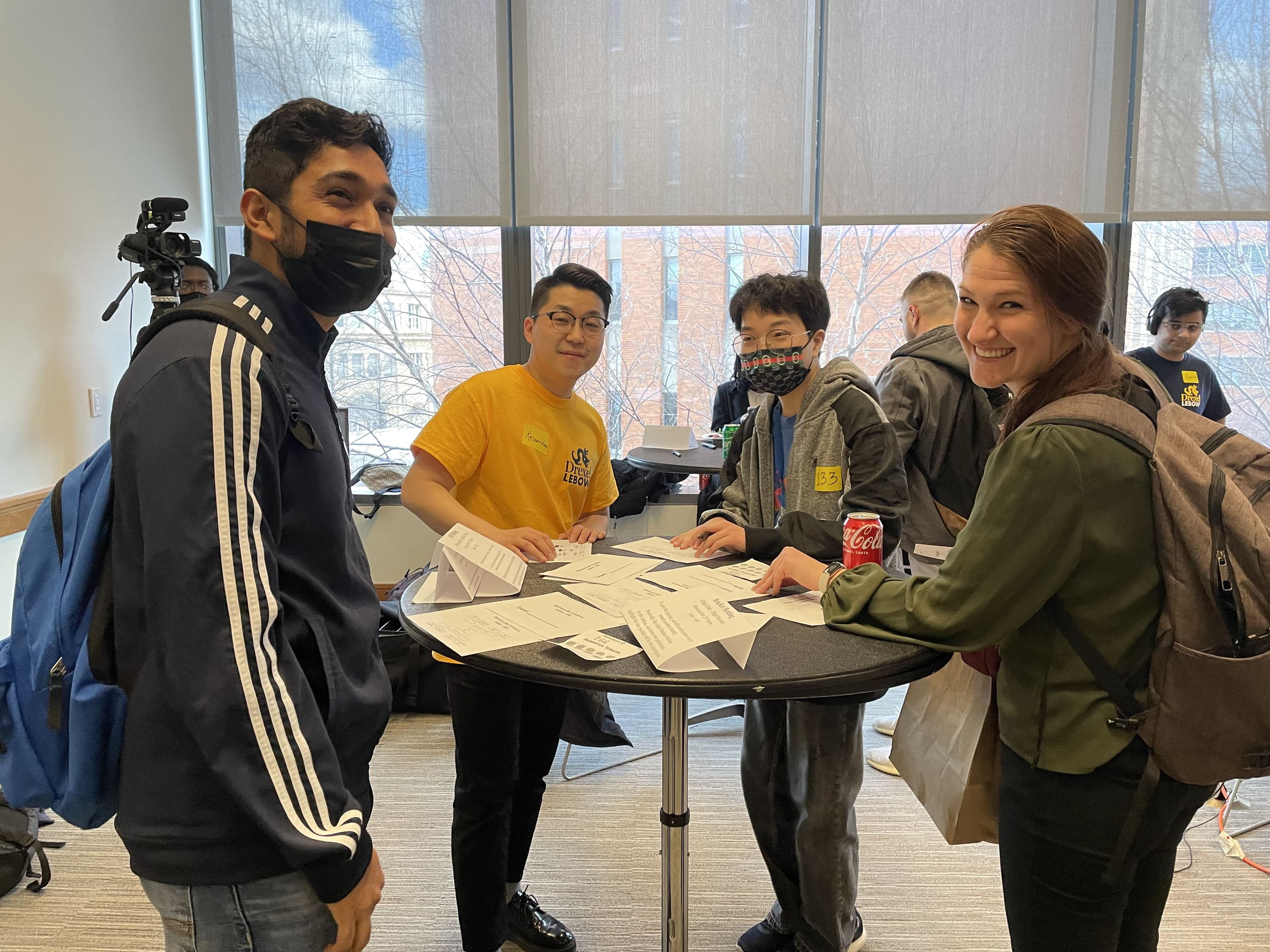 Youngdai Won leading the mock sports betting table with undergraduate and faculty participants including Kelly Walsh (Assistant Director of Academic Programs, Graduate Student Services) and students. Photo credit: Madison Miller.