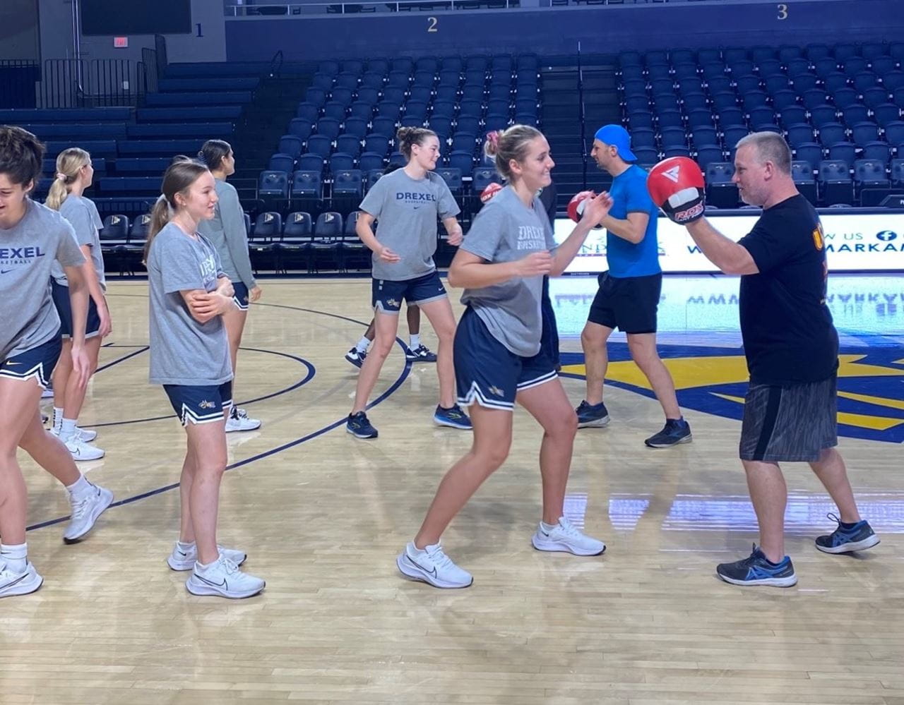 A row of female student-athletes waiting in lunch to practice self-defense.