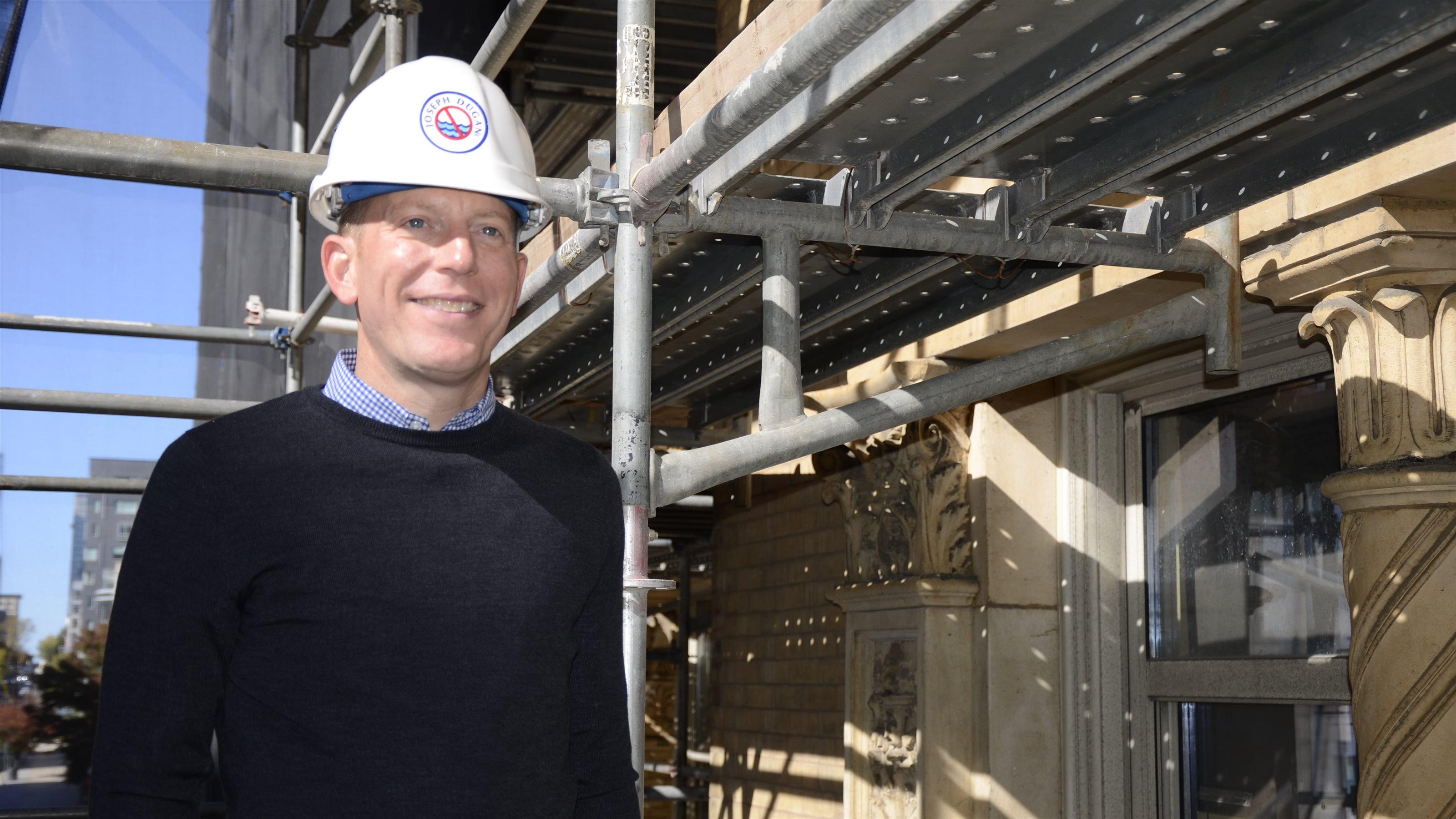 Colton Heimer stands on scaffolding.