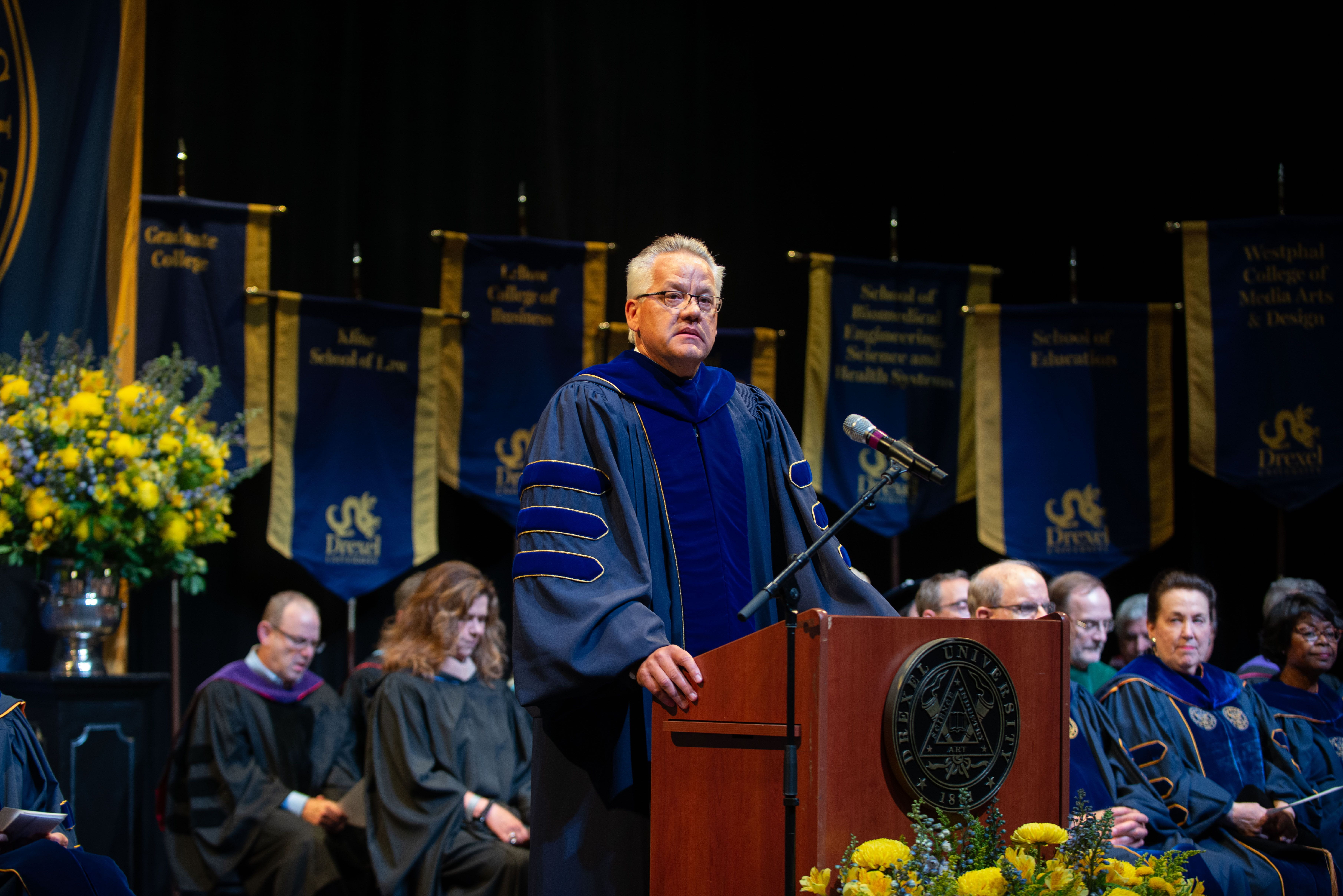 Paul Jensen stands at the podium at Drexel's 2022 Convocation ceremony. Photo credit: Shira Yudkoff Photography.