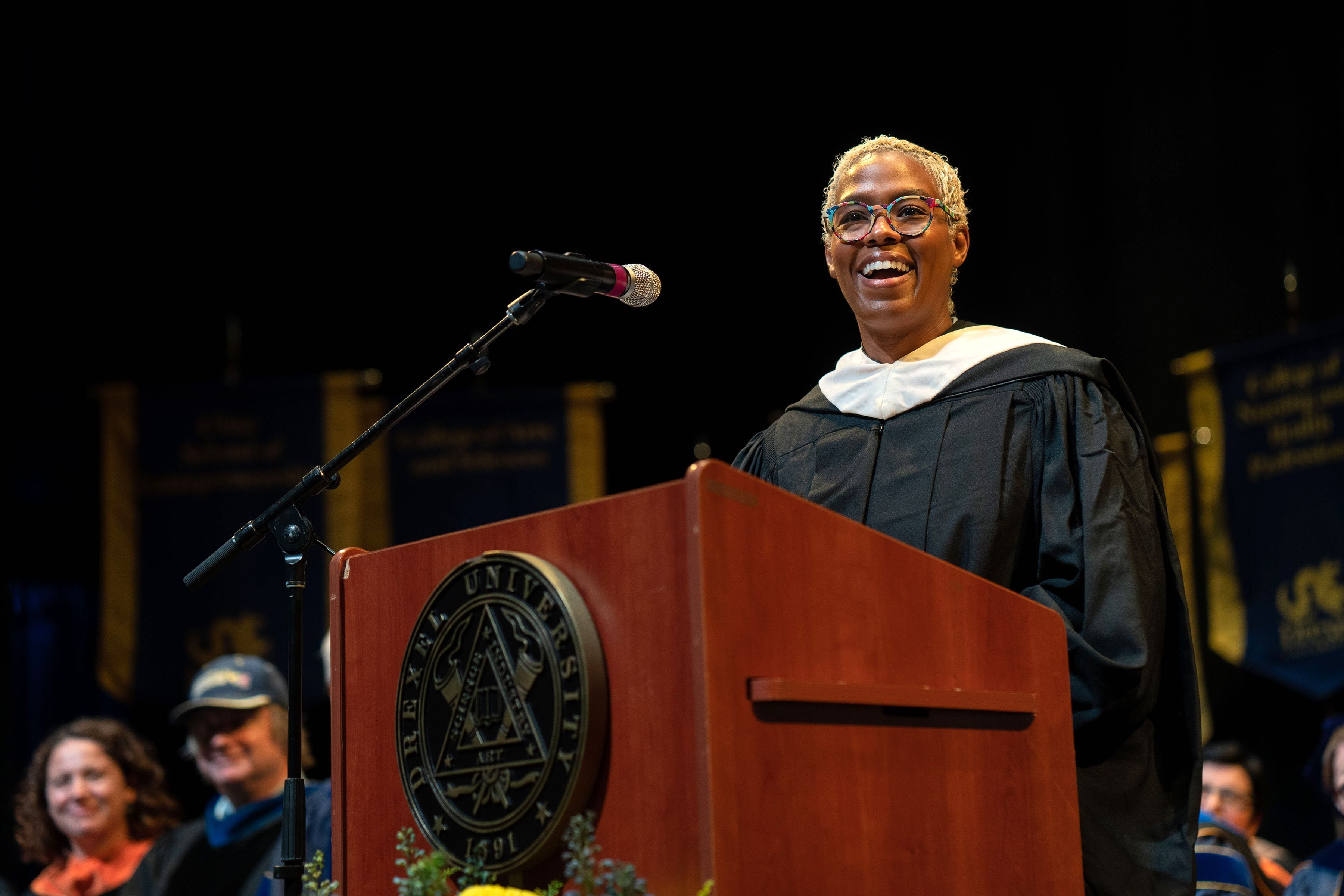Raja Schaar stands at the podium at Drexel's 2022 Convocation ceremony. Photo credit: Shira Yudkoff Photography.