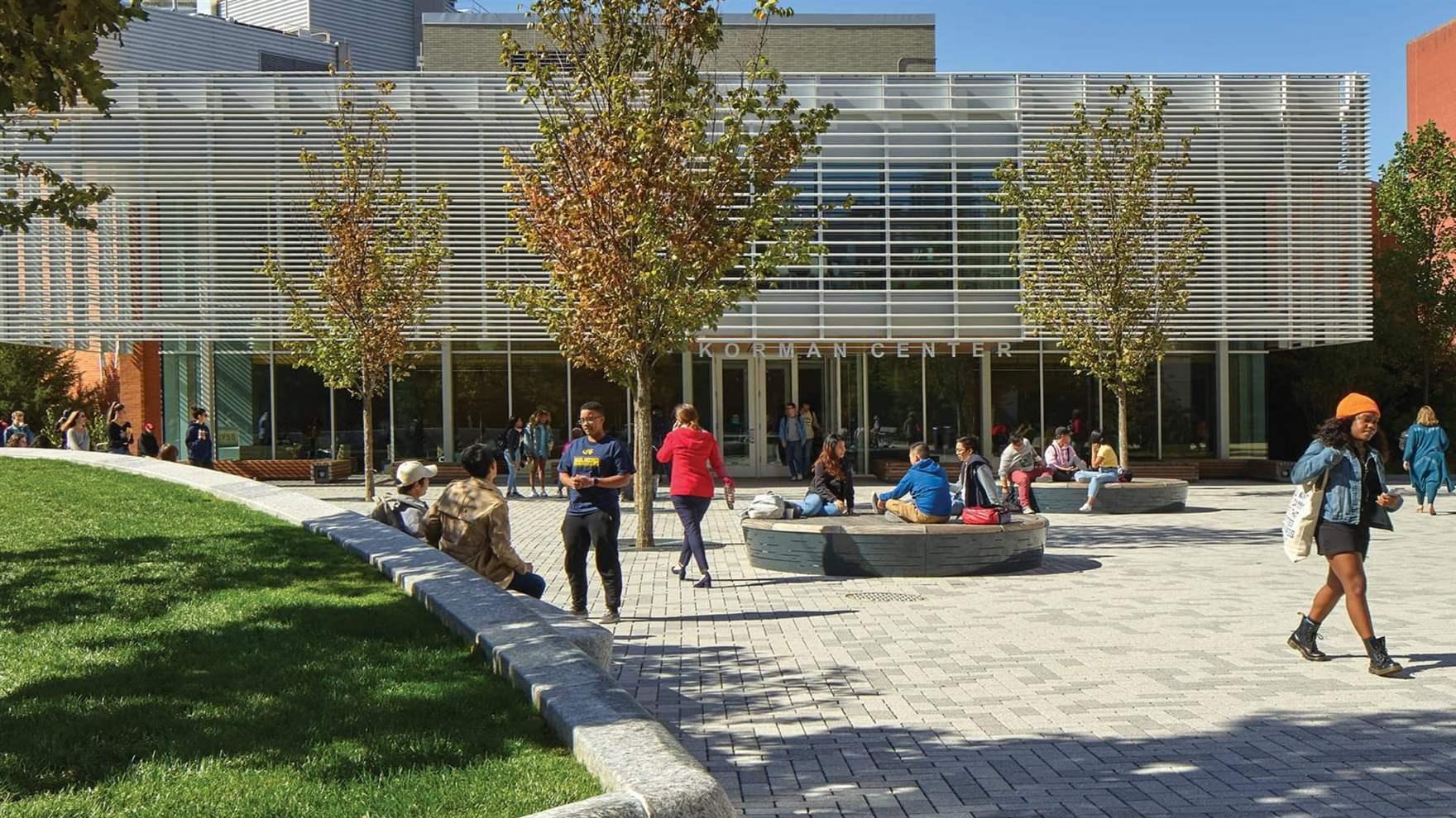 View of the Korman Center on the Korman Quad with people and trees.