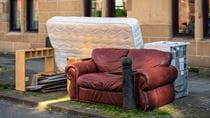 Discarded sofa, mattress and appliance curbside