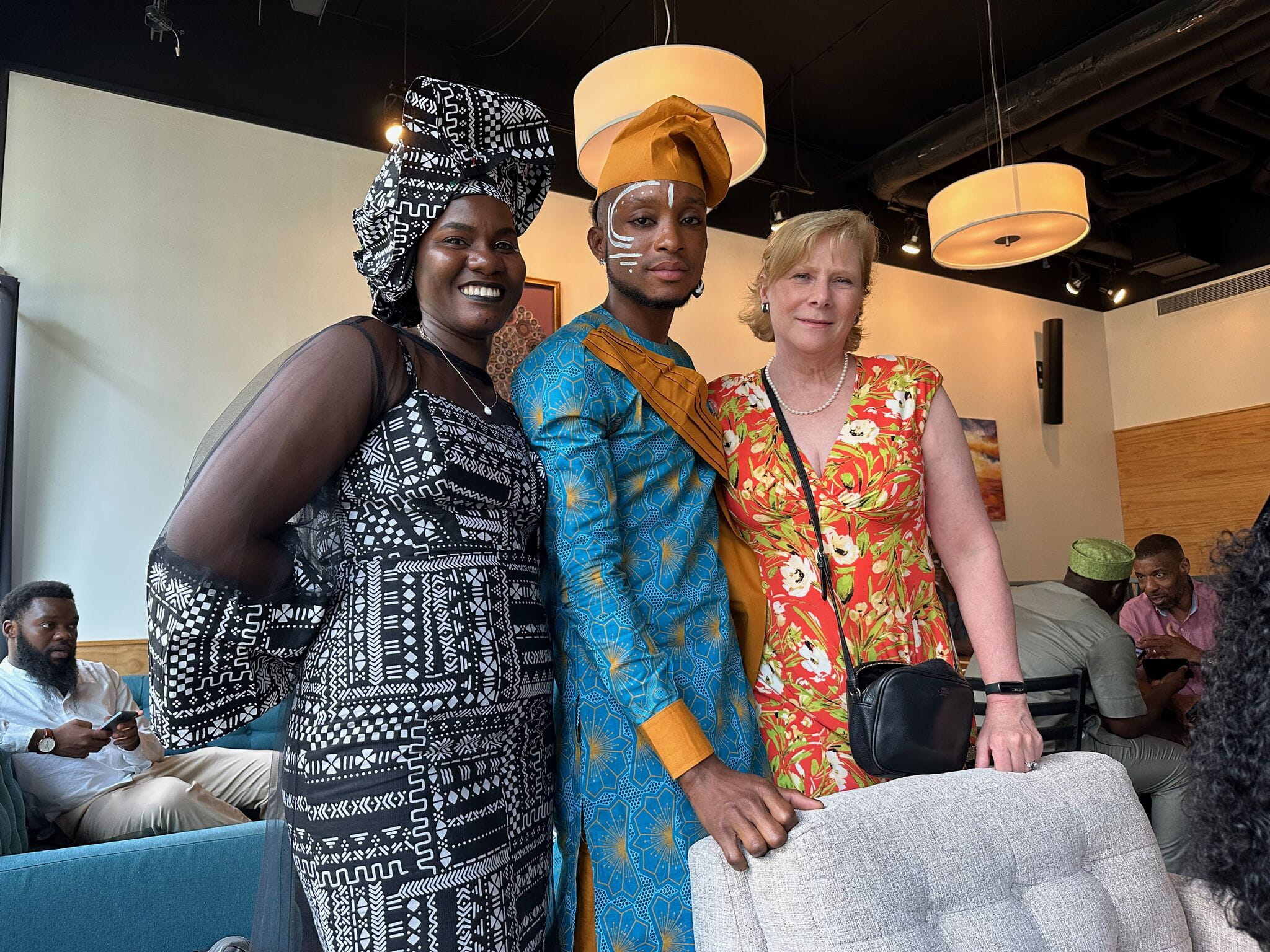 A woman, a man and a woman stand smiling at the camera