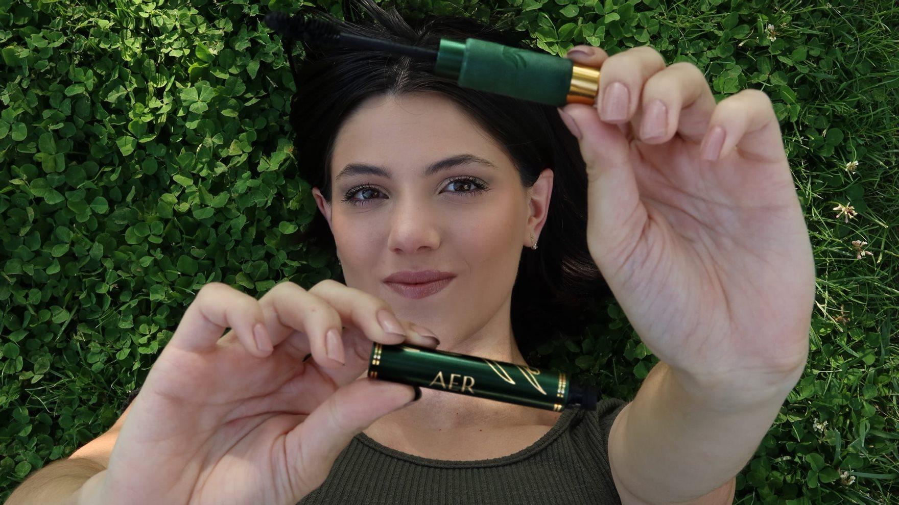 Paige Deangelo laying on grass showing mascara