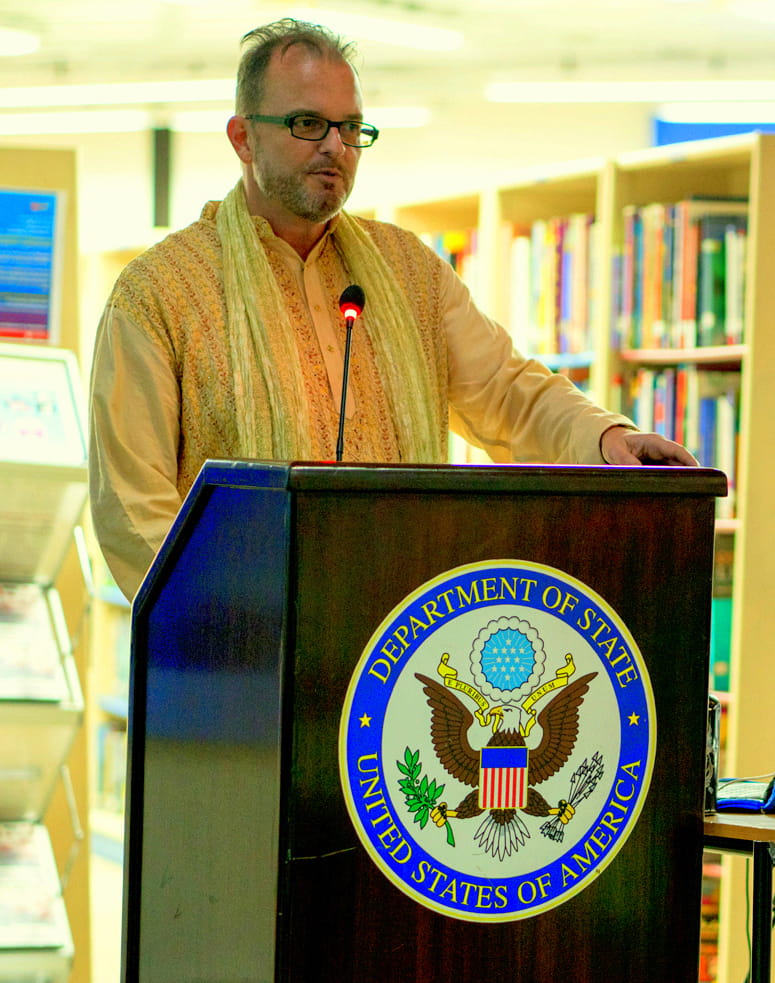 Jeffrey Stanley standing behind an official podium with the United States seal.