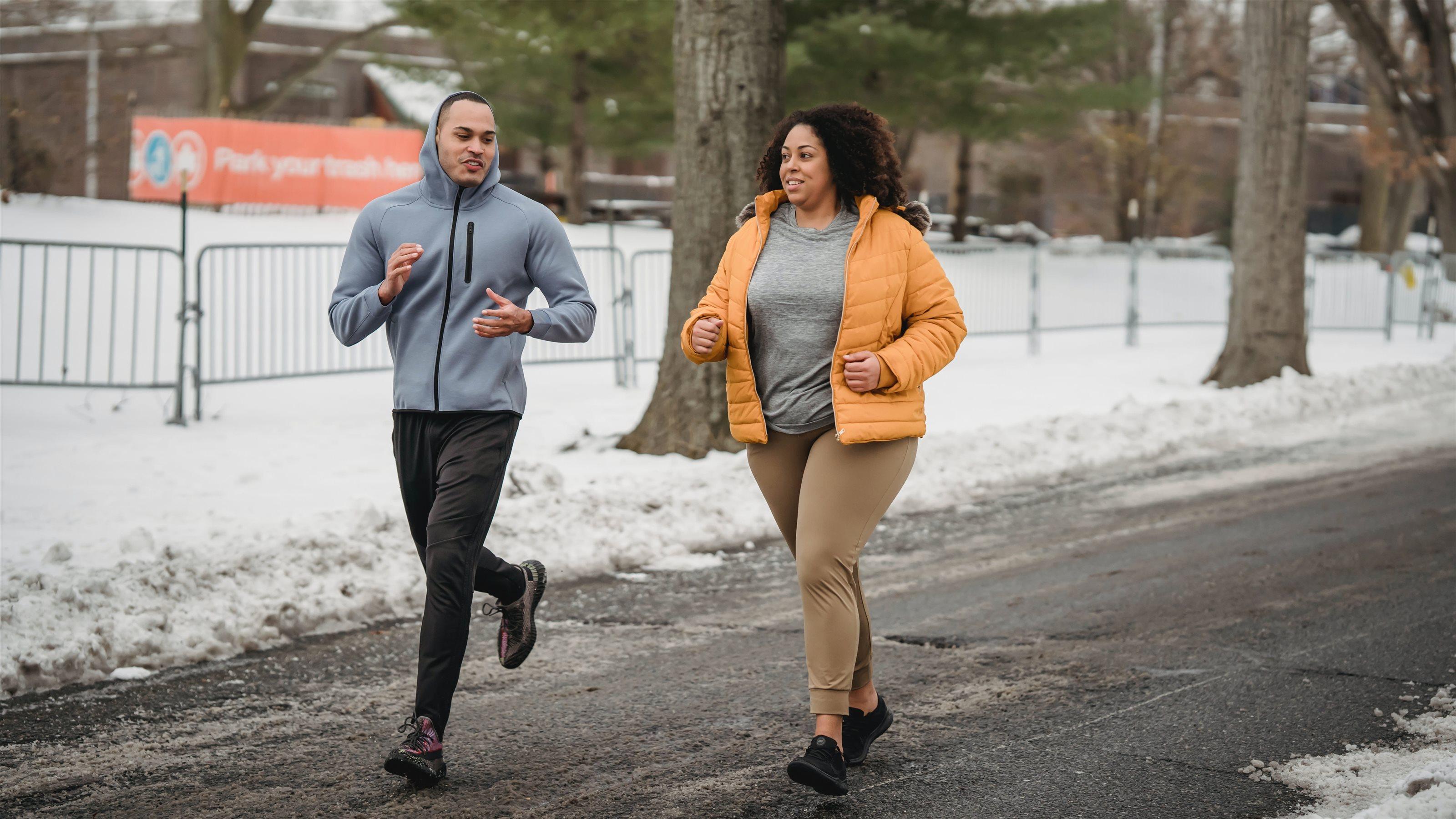 Man and woman running on snowy road