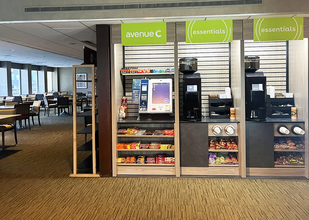 An area to purchase food items, candy displays and two coffee machines on a counter.