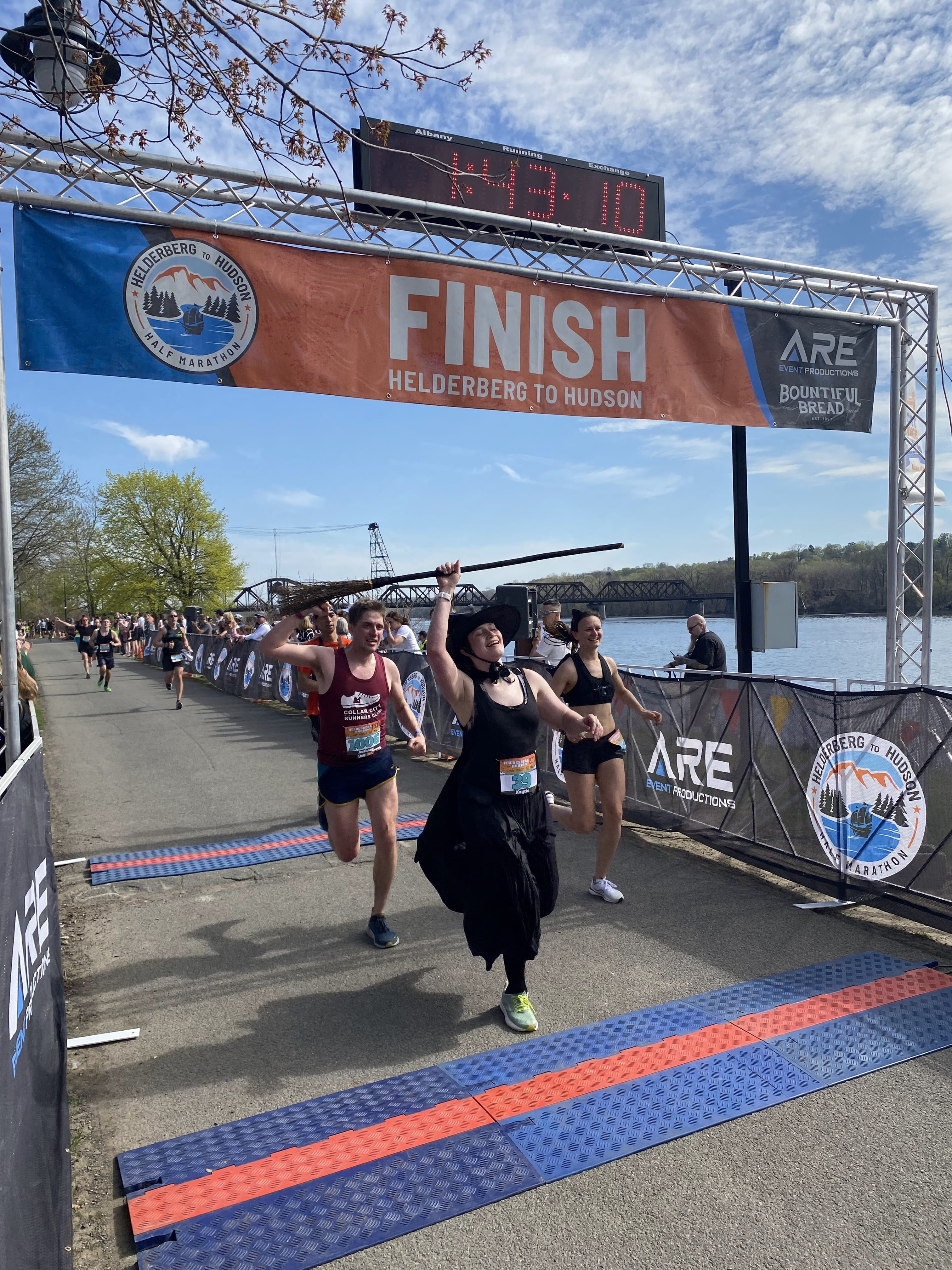 Kaytie Innamorati crossing the finish line in a witch costume.