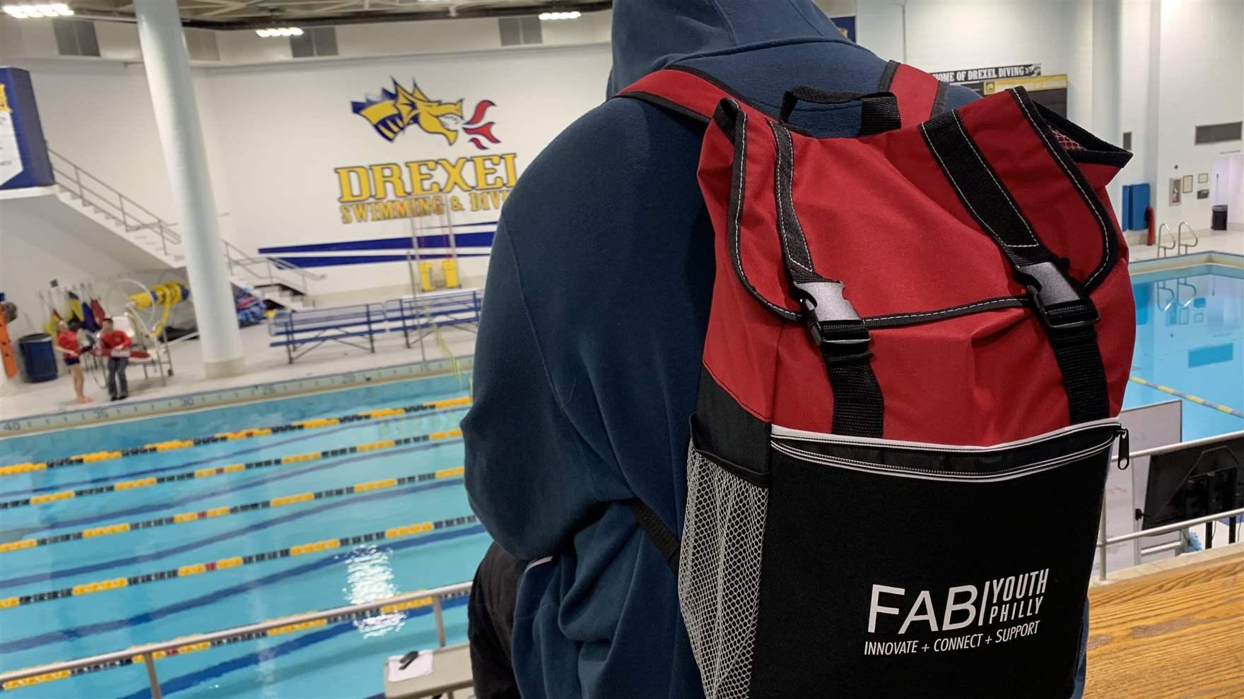 A teenager in a FAB Youth Philly backpack sits by the Drexel pool for training during this 12-week experience. Photo courtesy Rebecca Fabiano.
