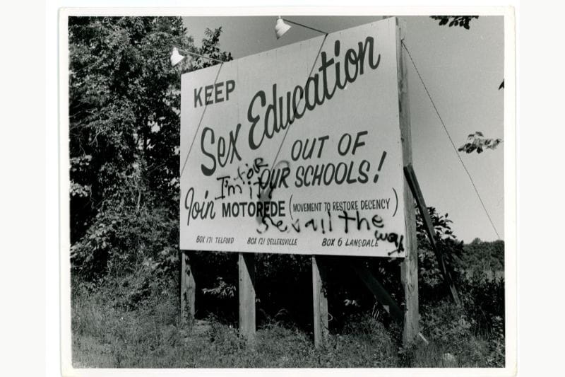  Road side sign advocating to "Keep Sex Education Out Of Our Schools" by the Movement to Restore Decency with locations in Telford, Sellersville, and Landsdale. A message spray painted over the sign reads, "I'm for it sex all the way." "One school of thought in the past," written on the back of the photo.