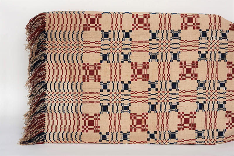Double woven coverlet. Cream with red and dark blue design, red and dark blue with blocks of plain weave in red and blue.  Given to Passmore Williamson while in prison for rescuing Jane Johnson and her children.