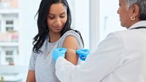 Woman getting a vaccine from a doctor