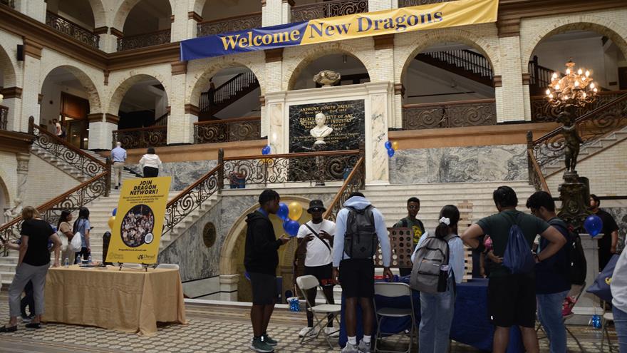 Students in Main building with Welcome New Dragons banner in background