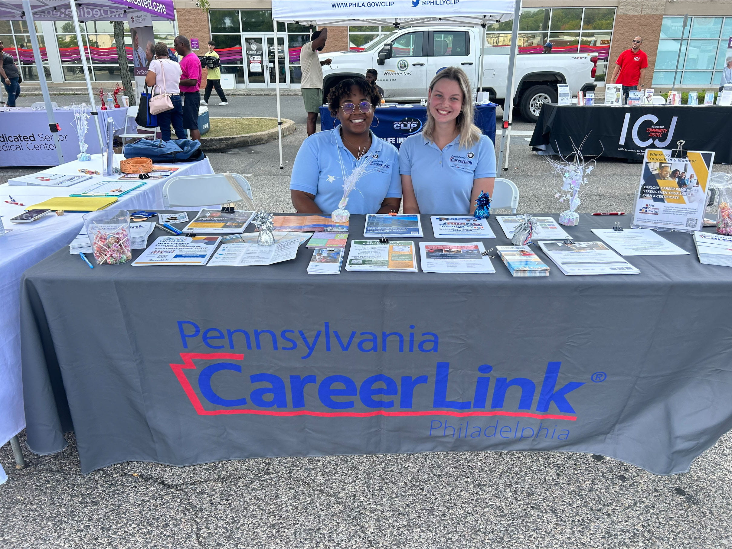 Two students sit behind a table with the words "Pennsylvania Career Link."