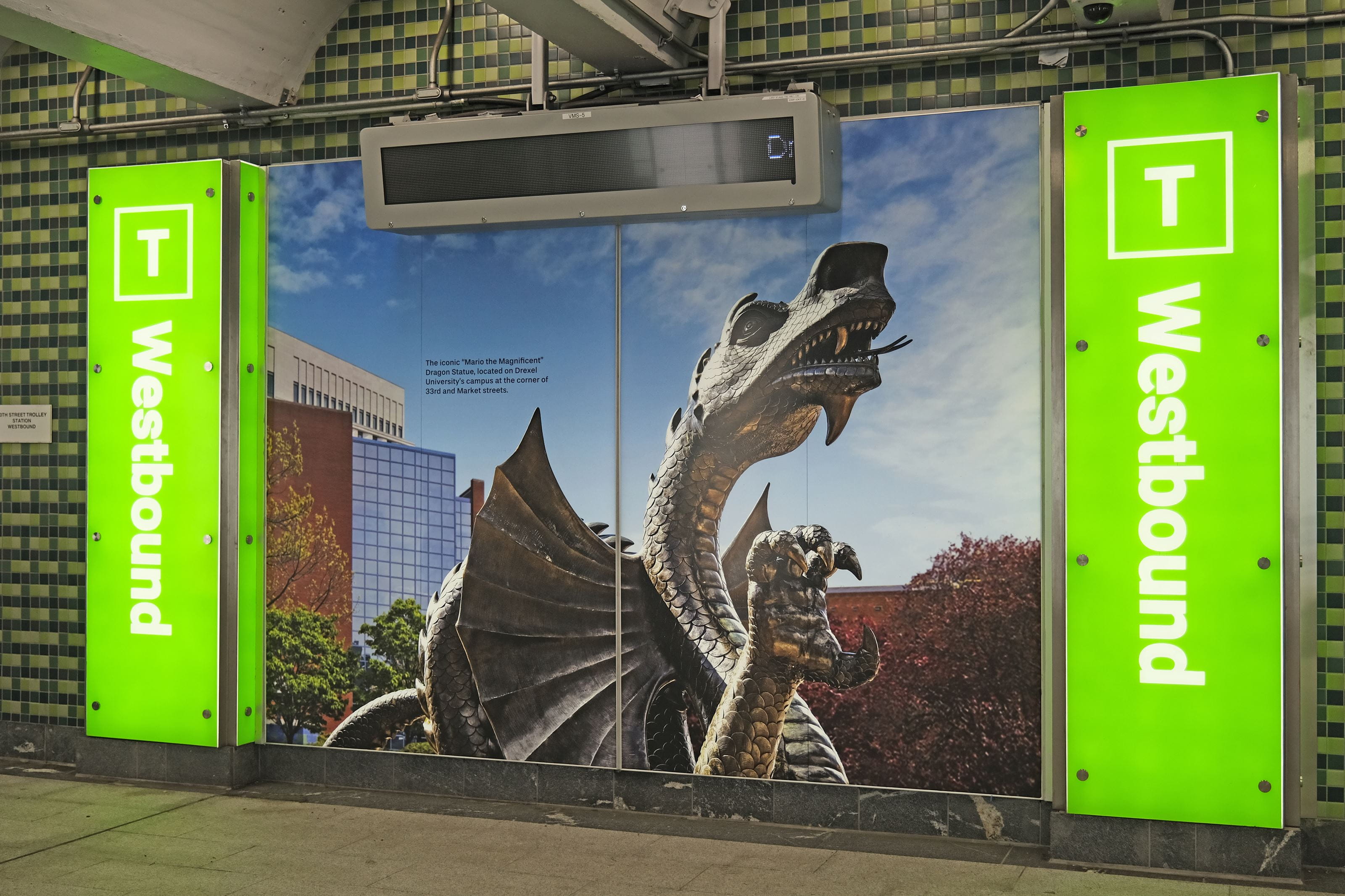 Westbound trolley stairs next to a picture of Mario the Magnificent at the Drexel Station at 30th Street. Photo courtesy Intersection.
