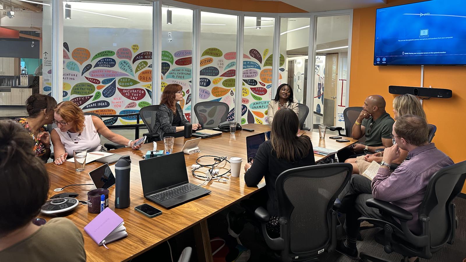 group of people sitting around a boardroom table conducting a meeting