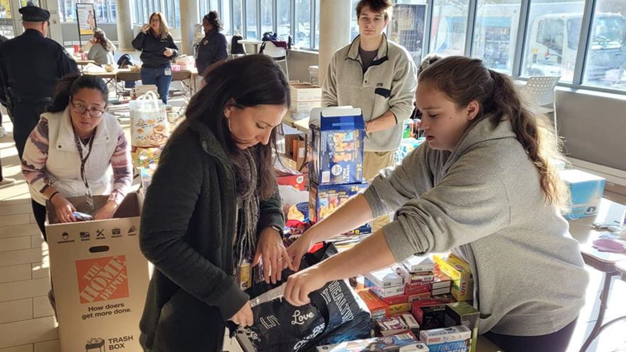 Students packing a box full of food.