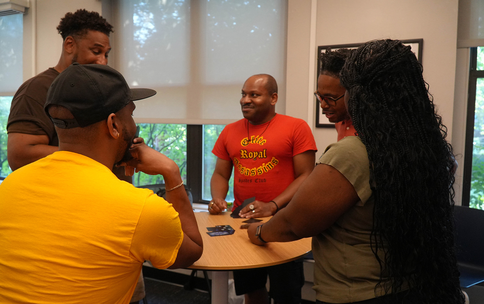 Dragons playing a card game at a table during the Juneteenth Celebration.