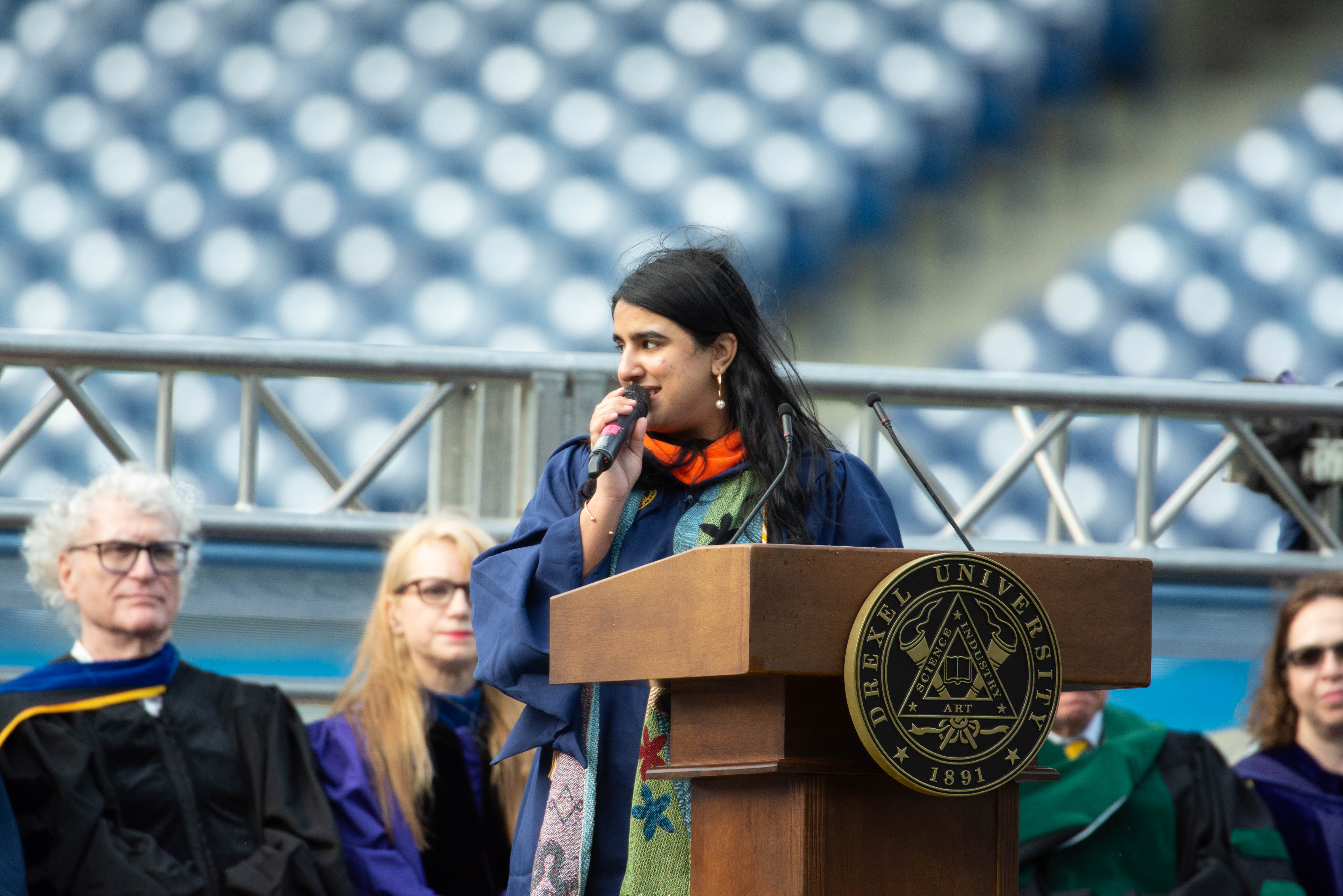 Cimi Patani speaking at the podium at Drexel University's 2024 Commencement ceremony.