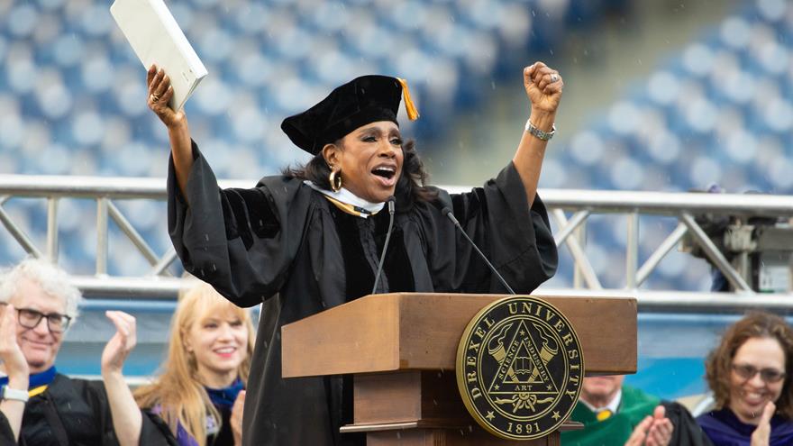 Sheryl Lee Ralph with arms raised while speaking at the podium at Drexel&#39;s 2024 Commencement.
