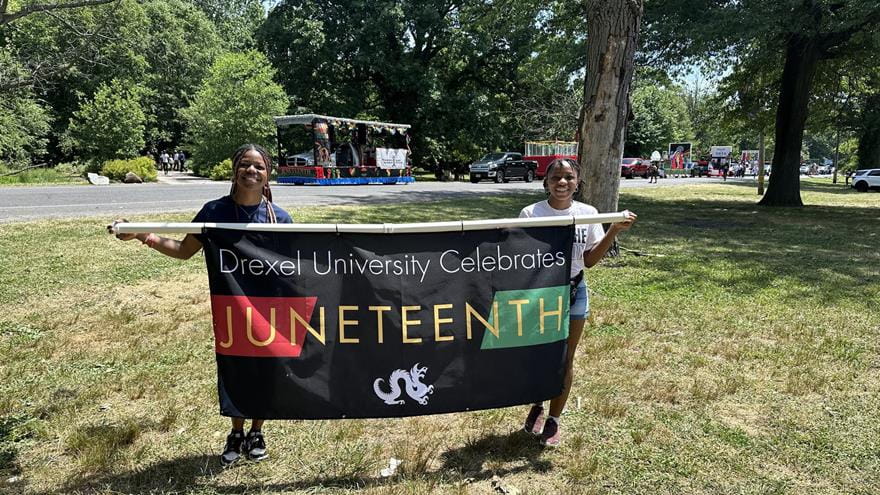 Two students holding a banner reading &quot;Drexel University Celebrated Juneteenth.&quot;