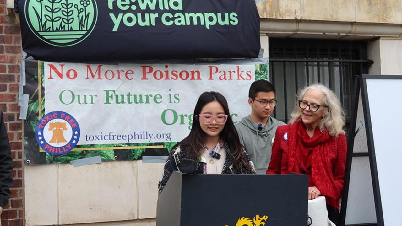 Turf announcement with banners and three people 